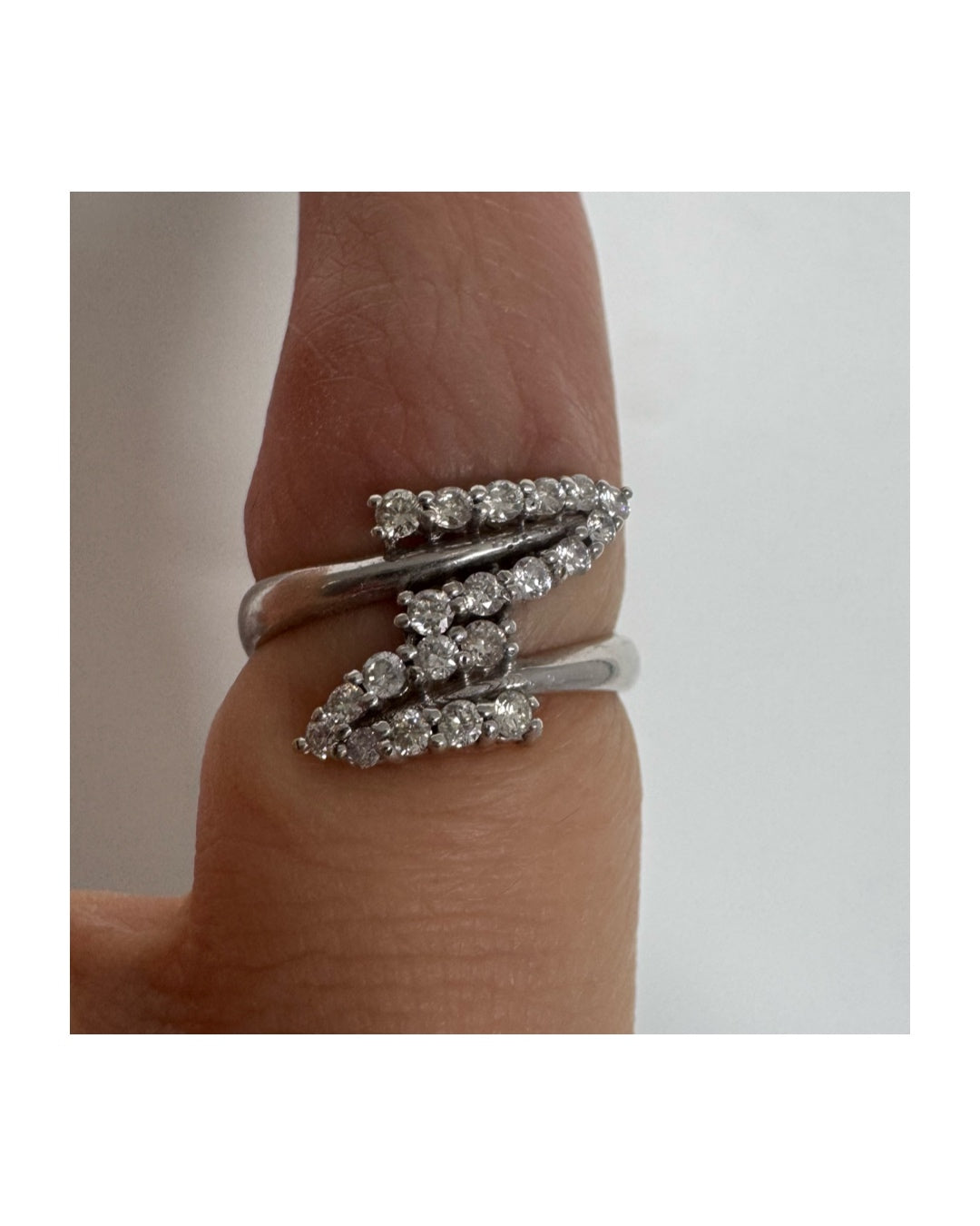 14K gold ring with an open design, featuring two curved rows of sparkling Diamonds that cross over each other elegantly.