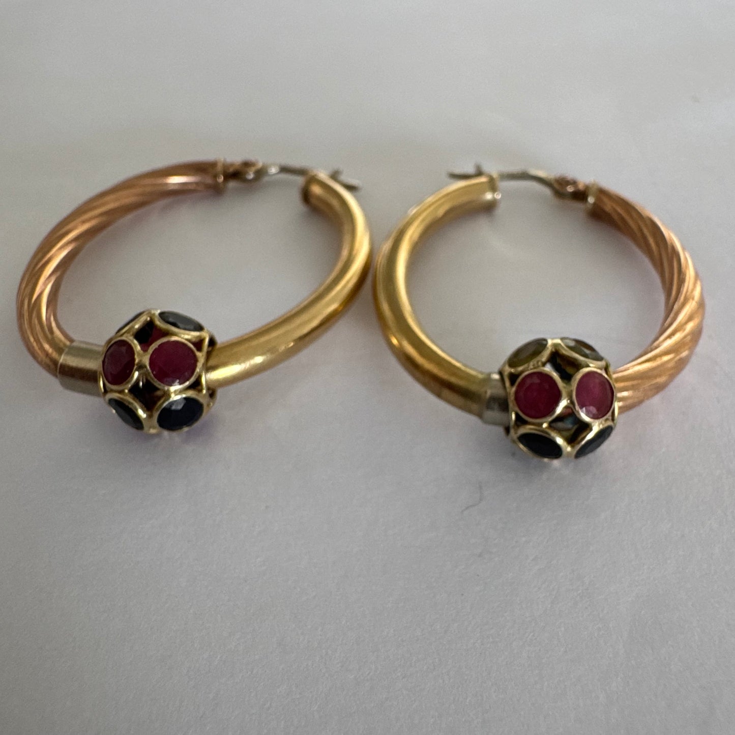 10K gold hoop earrings with a twisted design, set with pink and green Tourmaline.