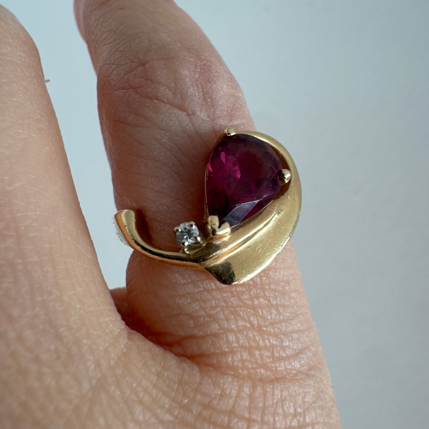 14K gold sculptural open ring set with a pear-cut pink Tourmaline, accented by a small Diamond.