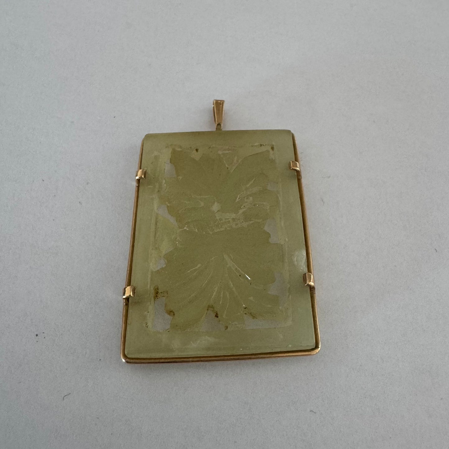 14K gold rectangular pendant set with a hand-carved milky Jade stone