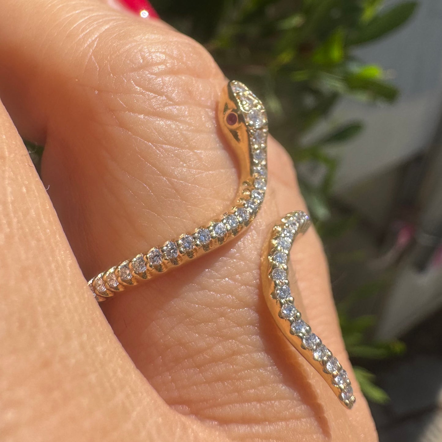 14K gold wrap-around snake ring, fully set with sparkling Diamonds along its body and head, finished with Rubies eyes
