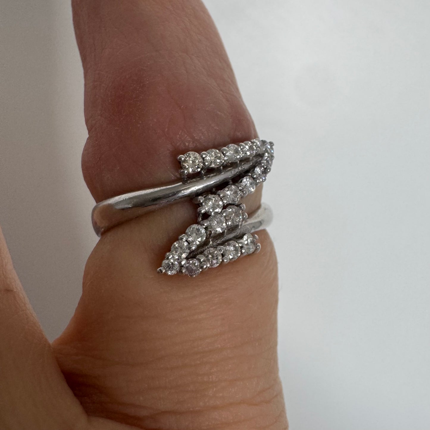 14K gold ring with an open design, featuring two curved rows of sparkling Diamonds that cross over each other elegantly.