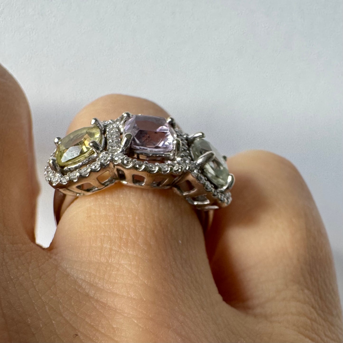 18K gold ring set with three pastel gemstones in soft shades of lilac, yellow and light gray