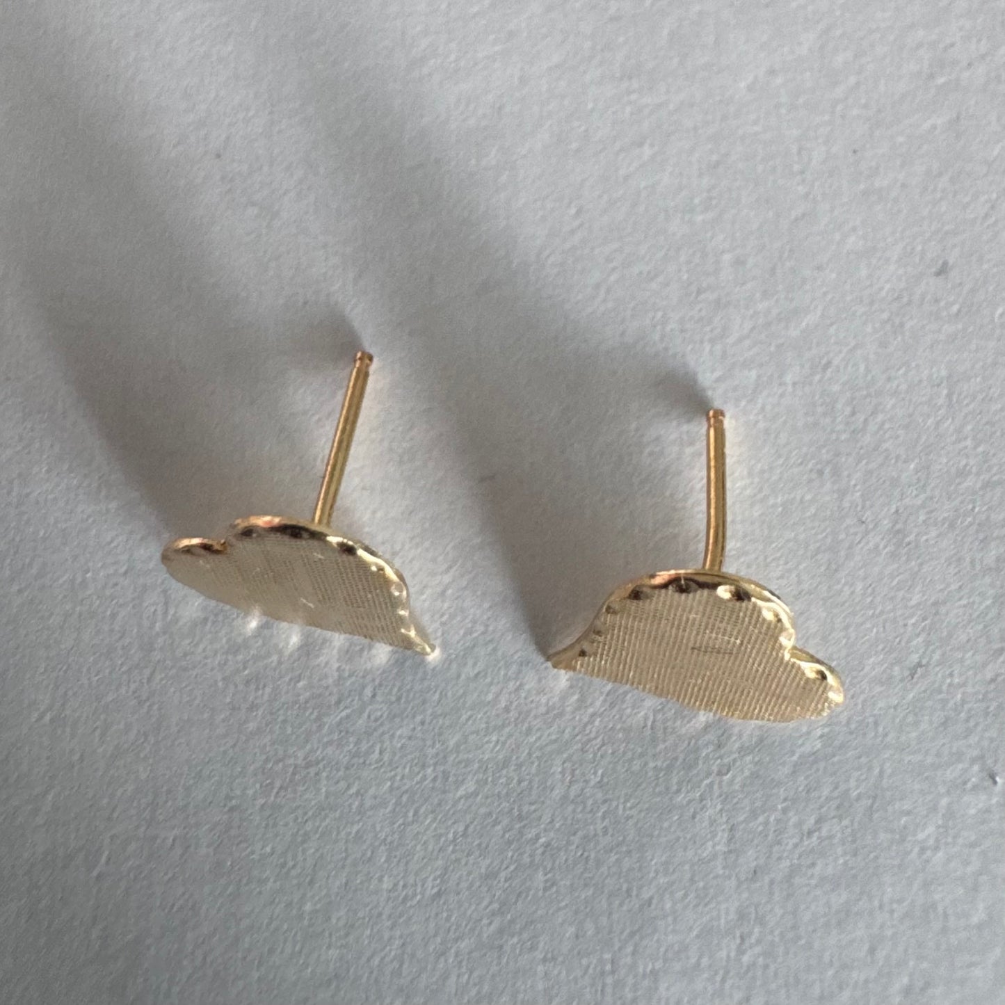 עגילי זהב צהוב 10 קראט בצורת לב, עם טקסטורה עדינה וגימור רך.