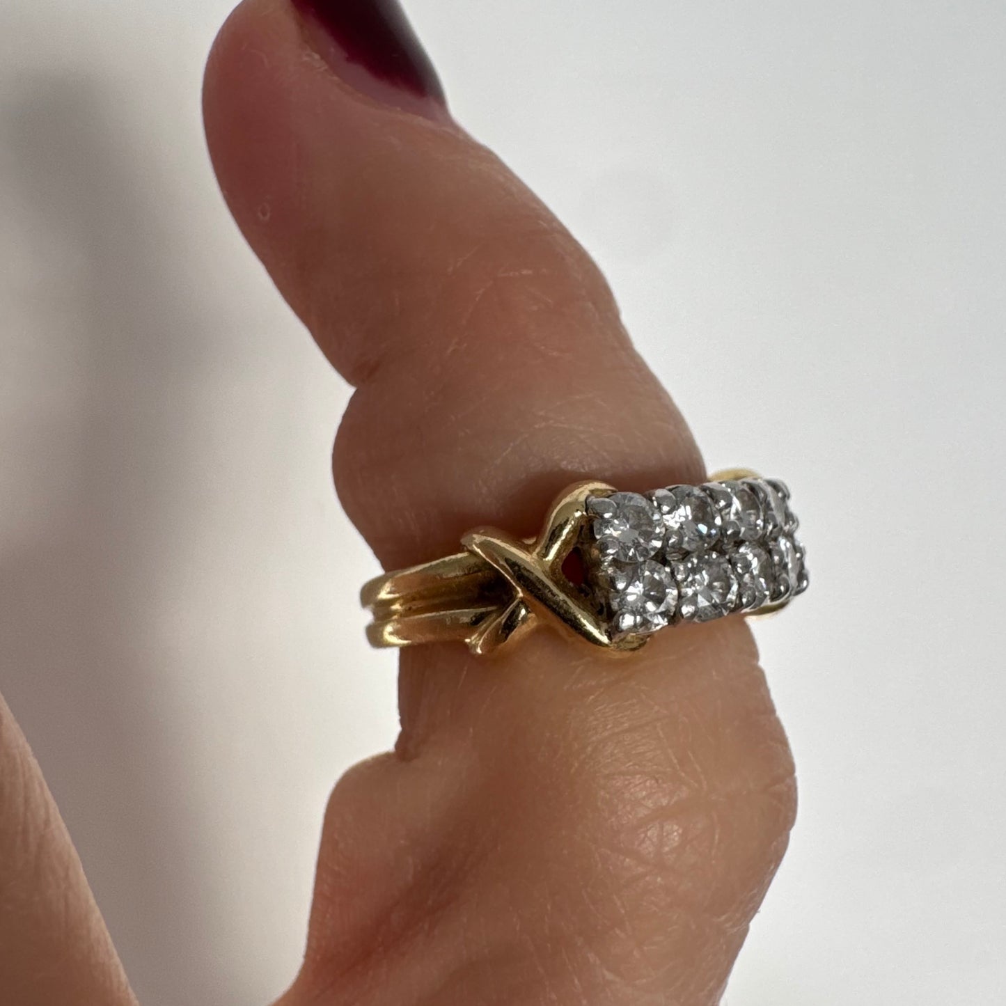 טבעת זהב צהוב 18 קראט משובצת יהלומים עגולים בשתי שורות צפופות, במבנה מלבני מעוגל.