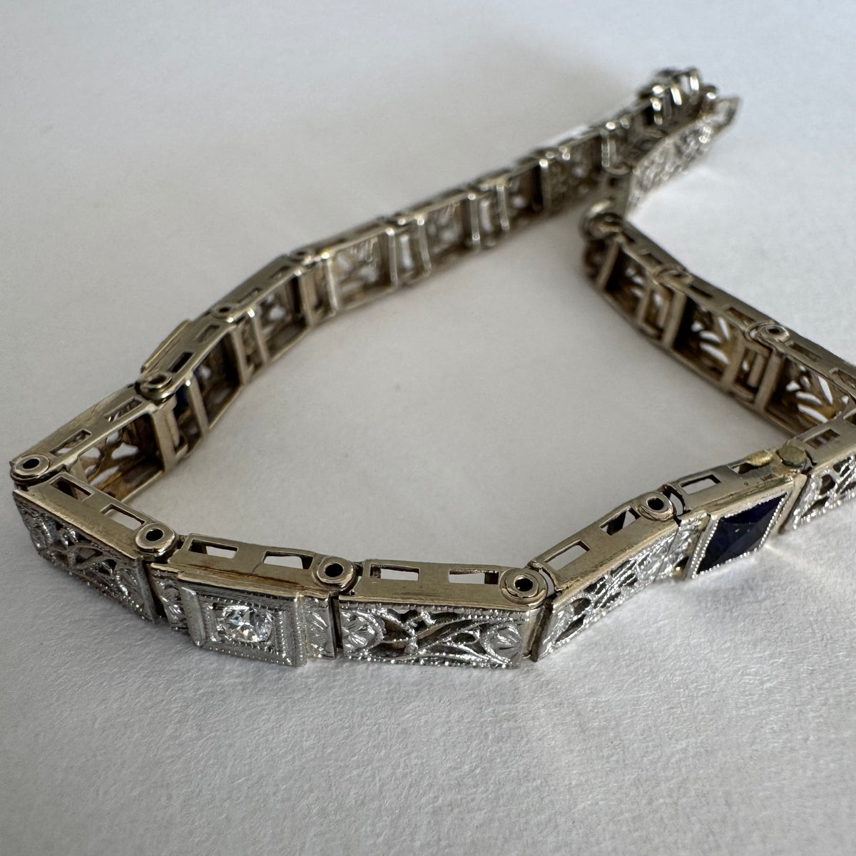14K gold bracelet featuring intricate openwork and beautifully engraved details set with Sapphire & Diamonds