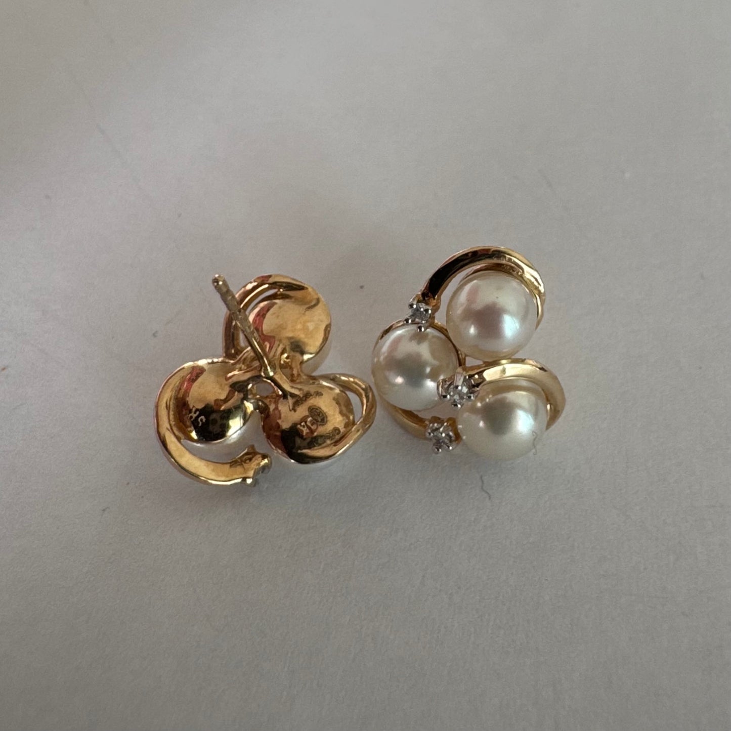 10K gold stud earrings in a delicate floral design, set with three creamy natural Pearls & Diamonds.