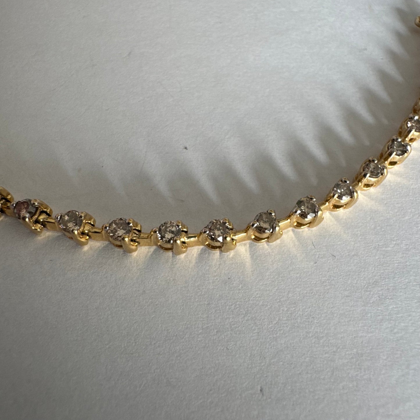 צמיד טניס מזהב צהוב 14 קראט משובץ שורת יהלומים, היוצרים ברק רציף ומראה נקי ועל-זמני.