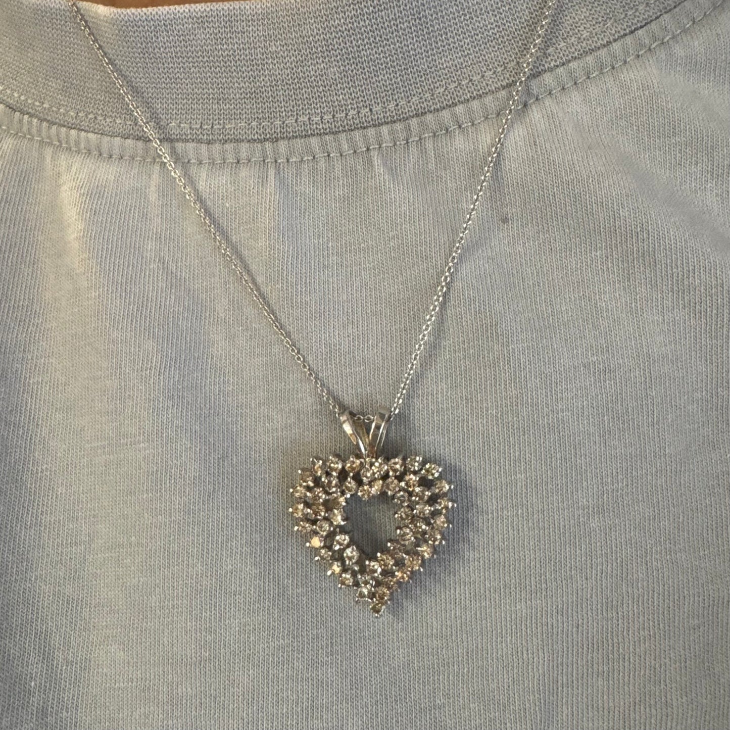 תליון לב זהב לבן 14 קראט, משובץ יהלומים בשיבוץ שיניים עדין היוצר מראה עשיר ומלא ברק.