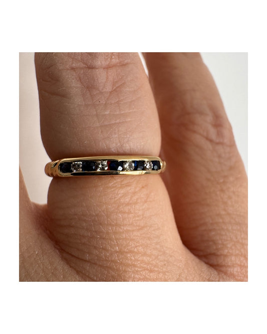 18K gold ring featuring a refined channel setting of deep blue Sapphires accented with Diamonds.
