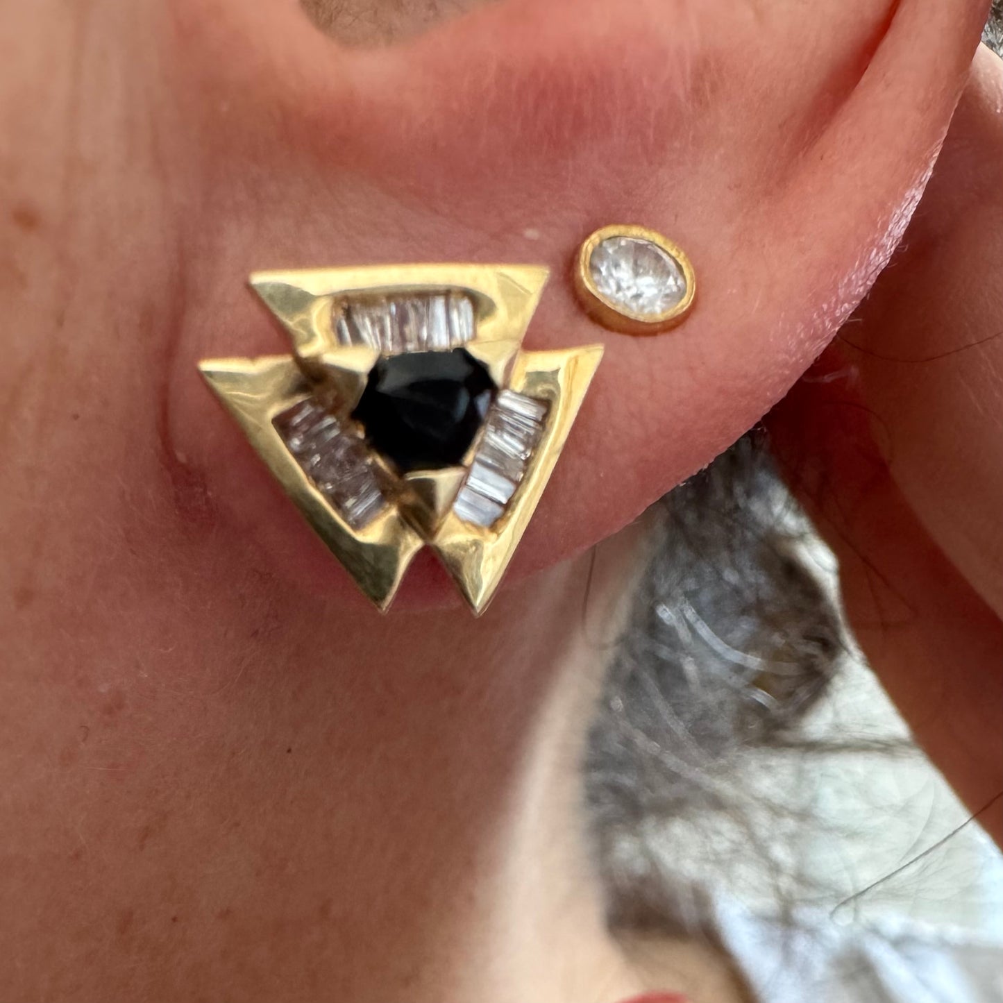 14K gold geometric stud earrings set with a Sapphire stone, surrounded by baguette Diamonds.