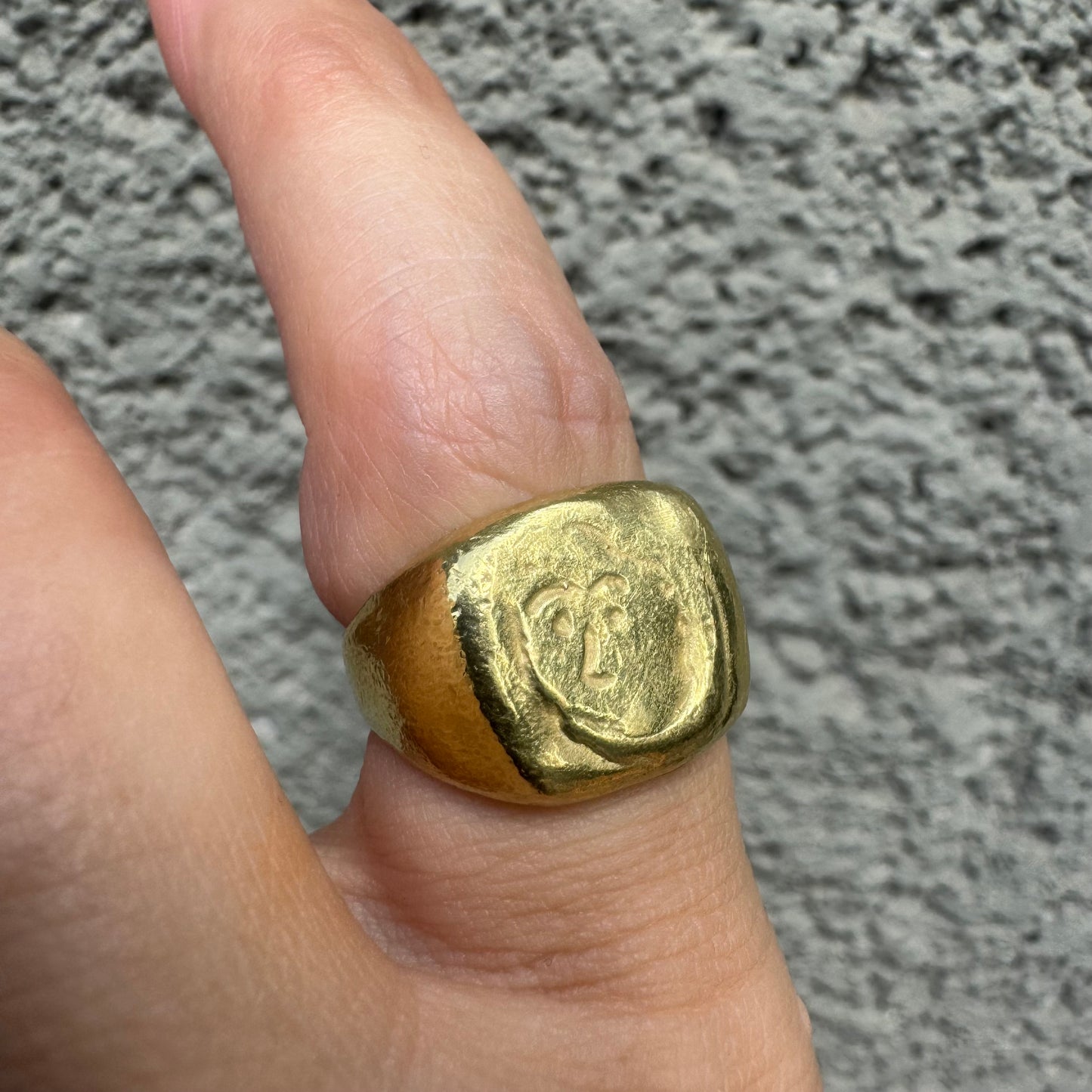 18K gold chunky gold ring with a rustic, organic finish, featuring an engraved abstract face motif at its center.
