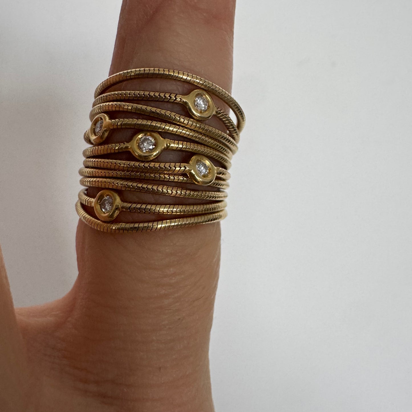 טבעת זהב צהוב 18 קראט של המותג H. Stern משובצת יהלומים בעיצוב רב־ליפופים אלגנטי 