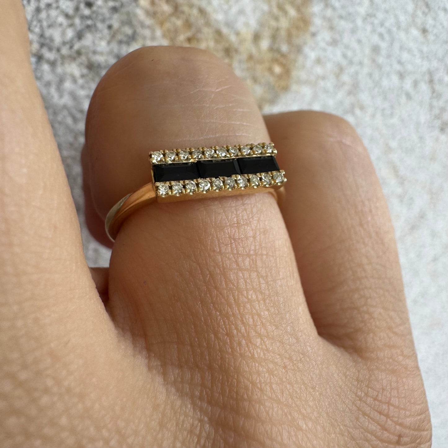 14K gold ring set with baguette-cut Sapphire framed by sparkling Diamonds