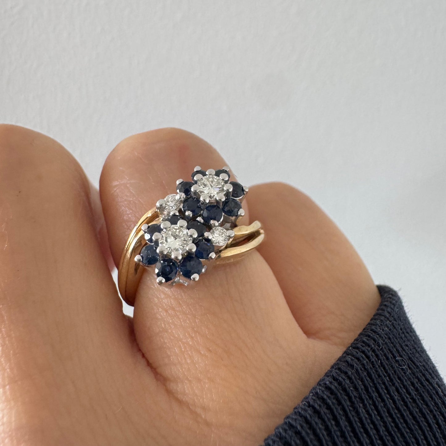 טבעת זהב צהוב 14 קראט משובצת אבני ספיר ויהלומים בעיצוב פרחים כפול.