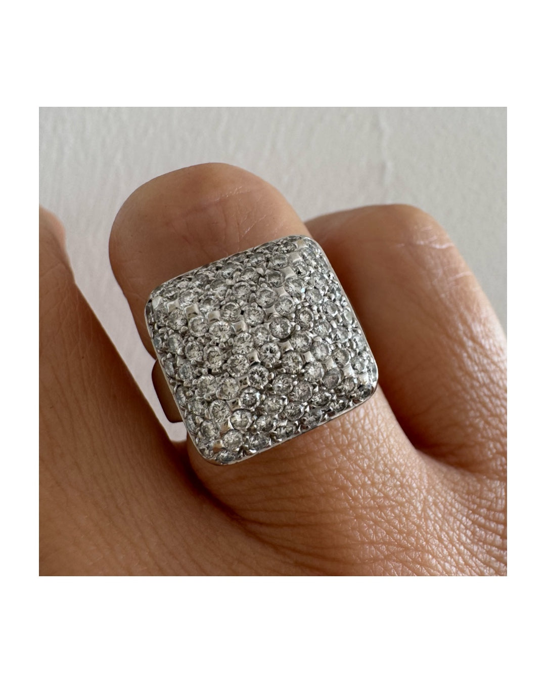 טבעת זהב לבן 18 קראט עם חלק עליון רחב בצורת ריבוע המשובץ כולו ביהלומים מנצנצים, ליצירת מראה יוקרתי ונוצץ.