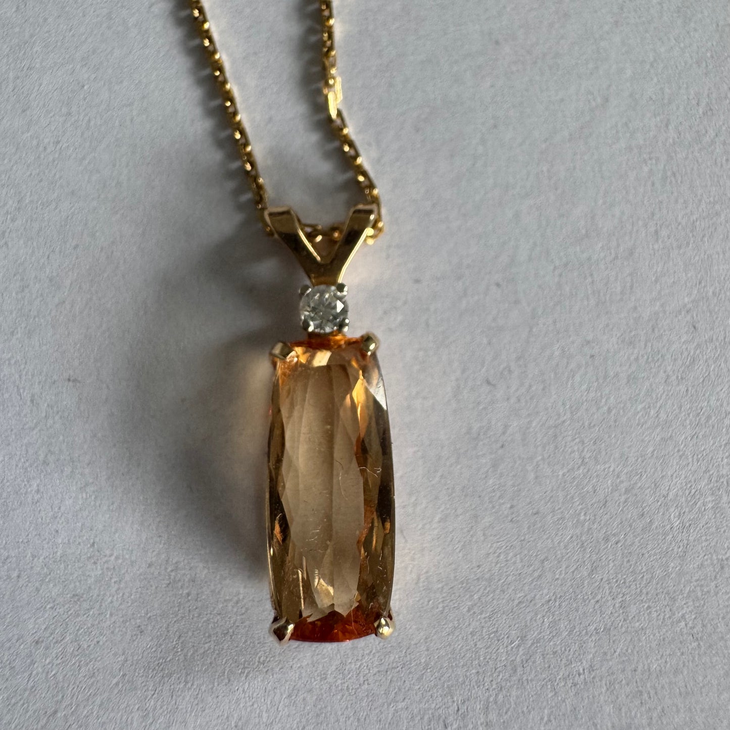 שרשרת זהב 14 קראט עם תליון זהב 14 קראט משובץ אבן קוורץ מלבנית בגוון שמפניה חמים, ומעליה יהלום נוצץ להדגשה עדינה של הברק.