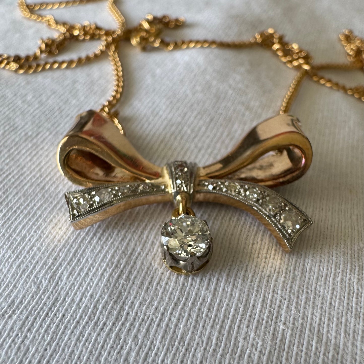 שרשרת זהב 18 קראט עם תליון בצורת סרט קלאסי משובץ יהלומים ונושא יהלום מרכזי תלוי שמוסיף נגיעה של זוהר ואלגנטיות