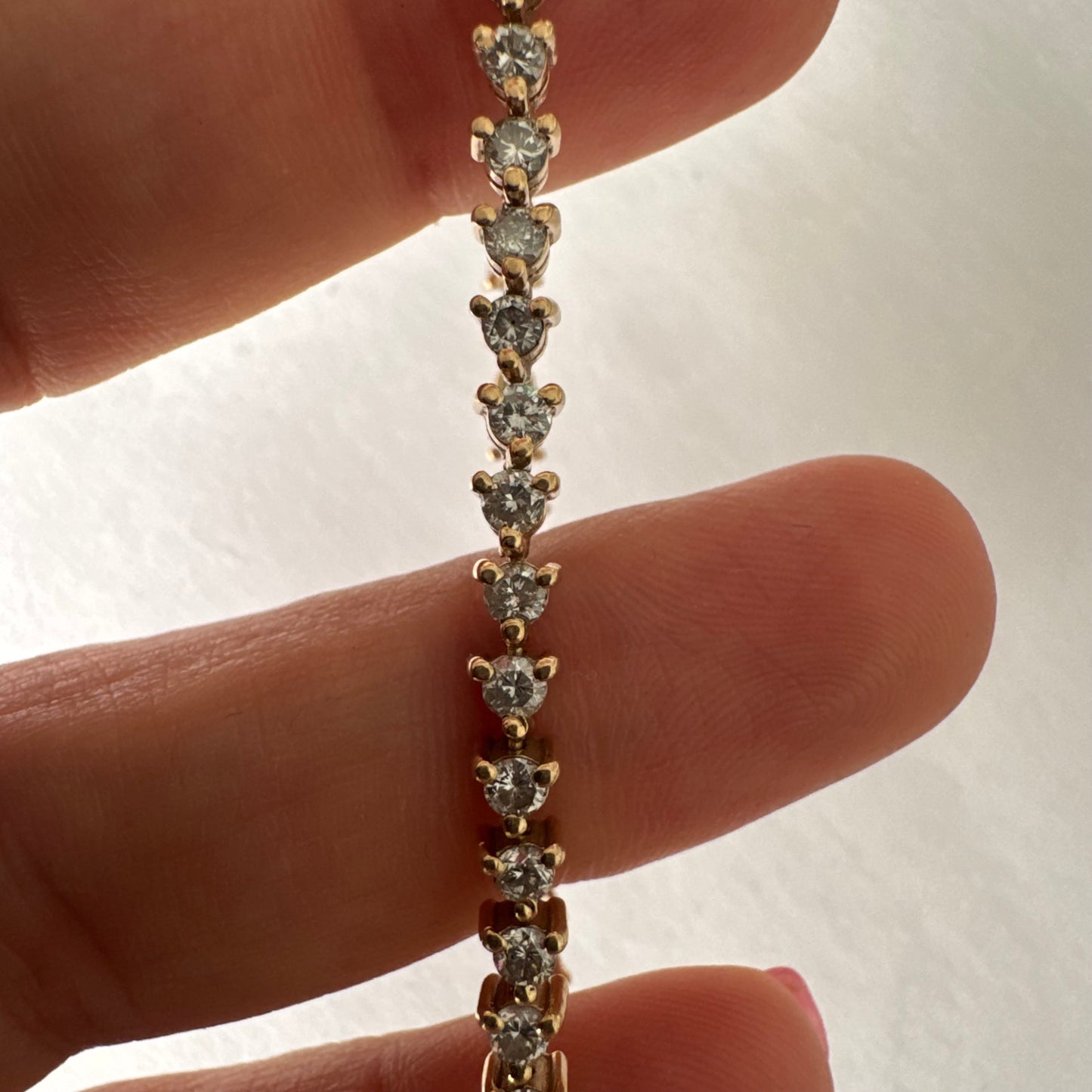 14K gold tennis bracelet set with a continuous line of round Diamonds, creating a delicate and elegant sparkle.