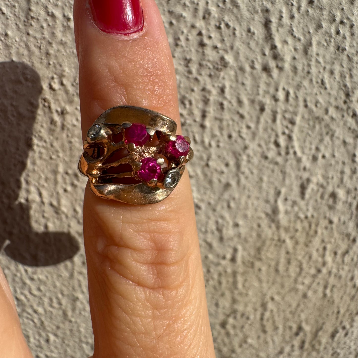 טבעת זהב צהוב 14 קראט, משובצת אבני רובי ושני יהלומים להדגשה, בעיצוב פיסולי ומלא אופי.