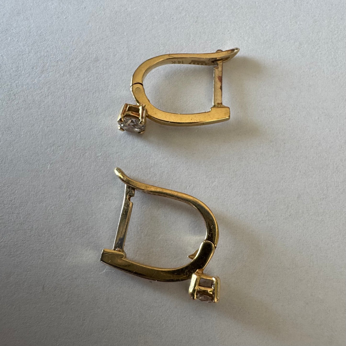14K gold earrings set with round brilliant-cut Diamonds.