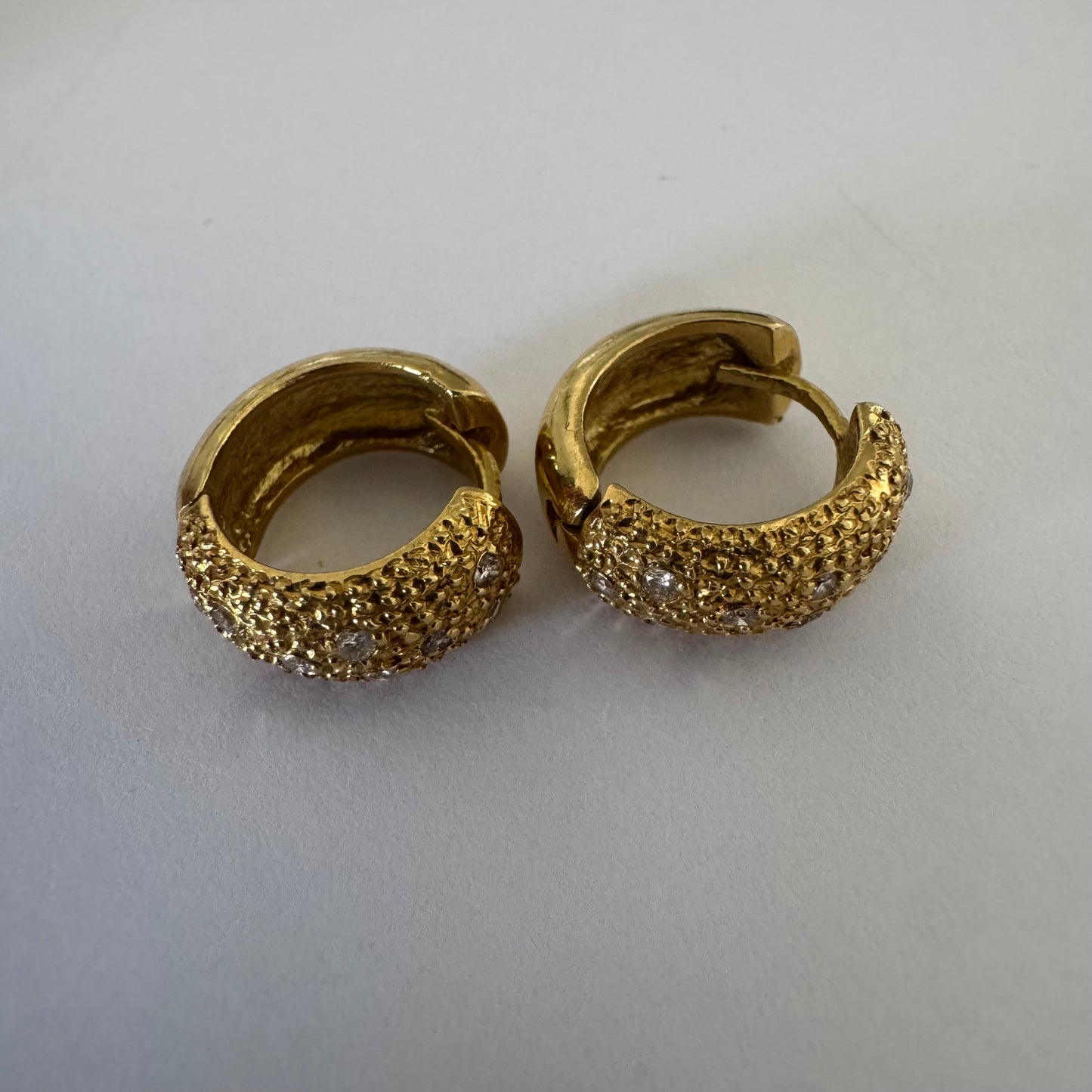 18K gold hoop earrings designed with a rich organic texture and set with Diamonds