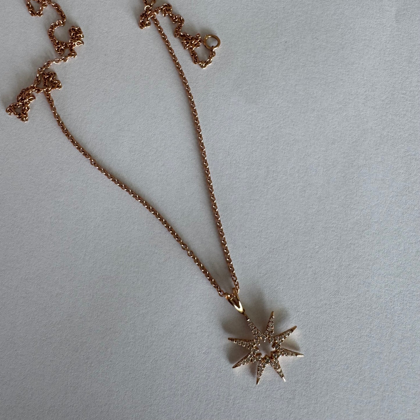 שרשרת זהב 14 קראט עם תליון בצורת כוכב משובץ יהלומים.