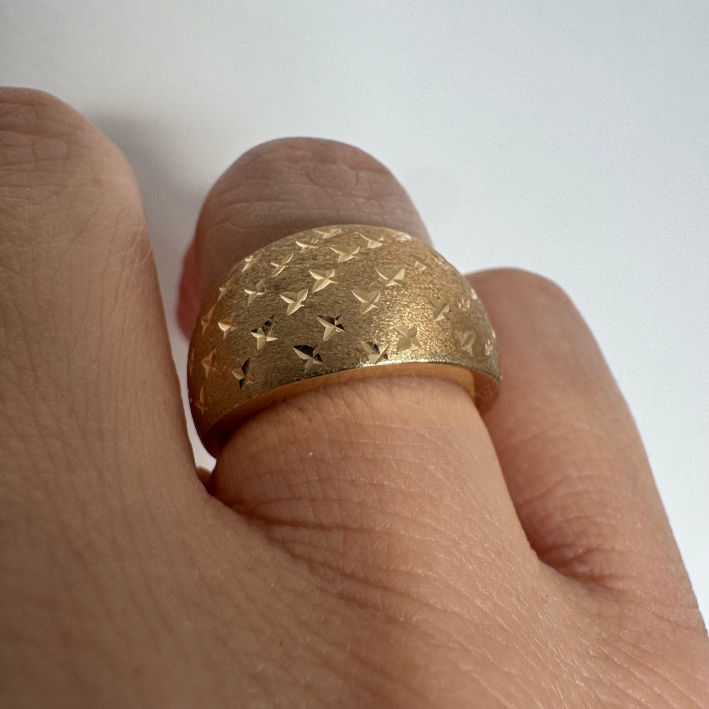 14K gold wide signet-style ring with a matte finish and delicate star engravings.