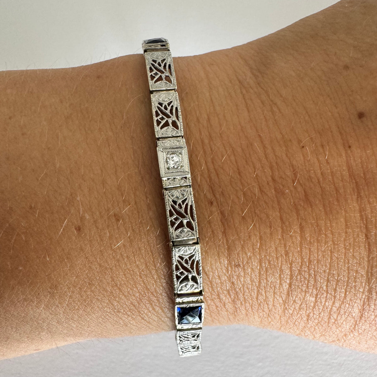 14K gold bracelet featuring intricate openwork and beautifully engraved details set with Sapphire & Diamonds