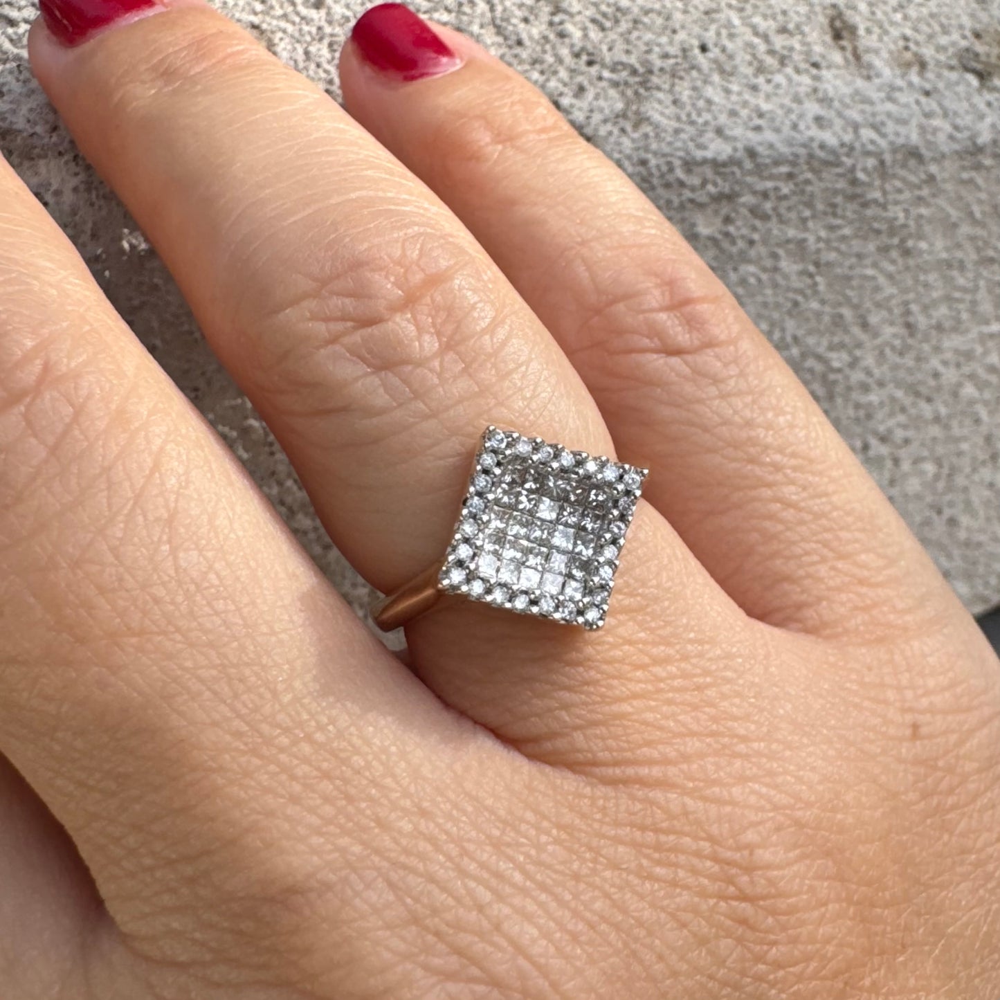 טבעת זהב 14 קראט בעיצוב ריבועי משובצת יהלומים בחיתוך פרינסס ומוקפת מסגרת יהלומים עגולים. 