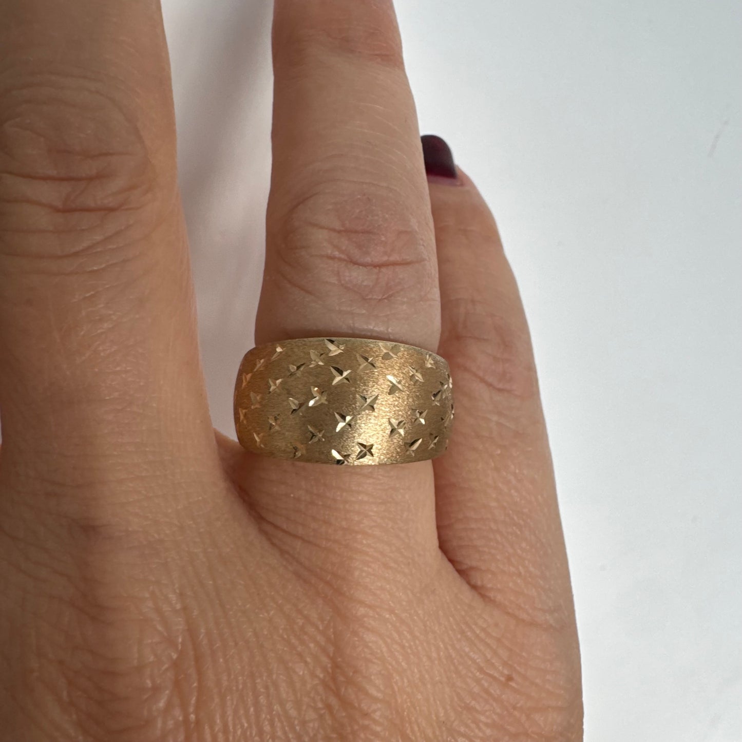 14K gold wide signet-style ring with a matte finish and delicate star engravings.