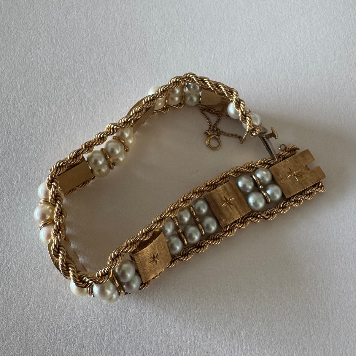 14K gold bracelet set with Pearls, featuring intricate rope-style detailing and textured geometric gold elements.