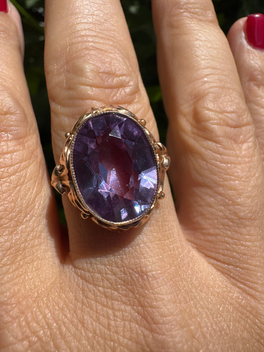 14K gold ring set with a large oval-cut Amethyst in a regal claw setting.