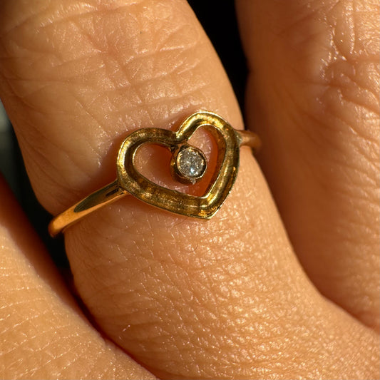 טבעת זהב 14 קראט בעיצוב לב פתוח ועדין, עם יהלום קטן במרכז שמוסיף נקודת אור אלגנטית. 