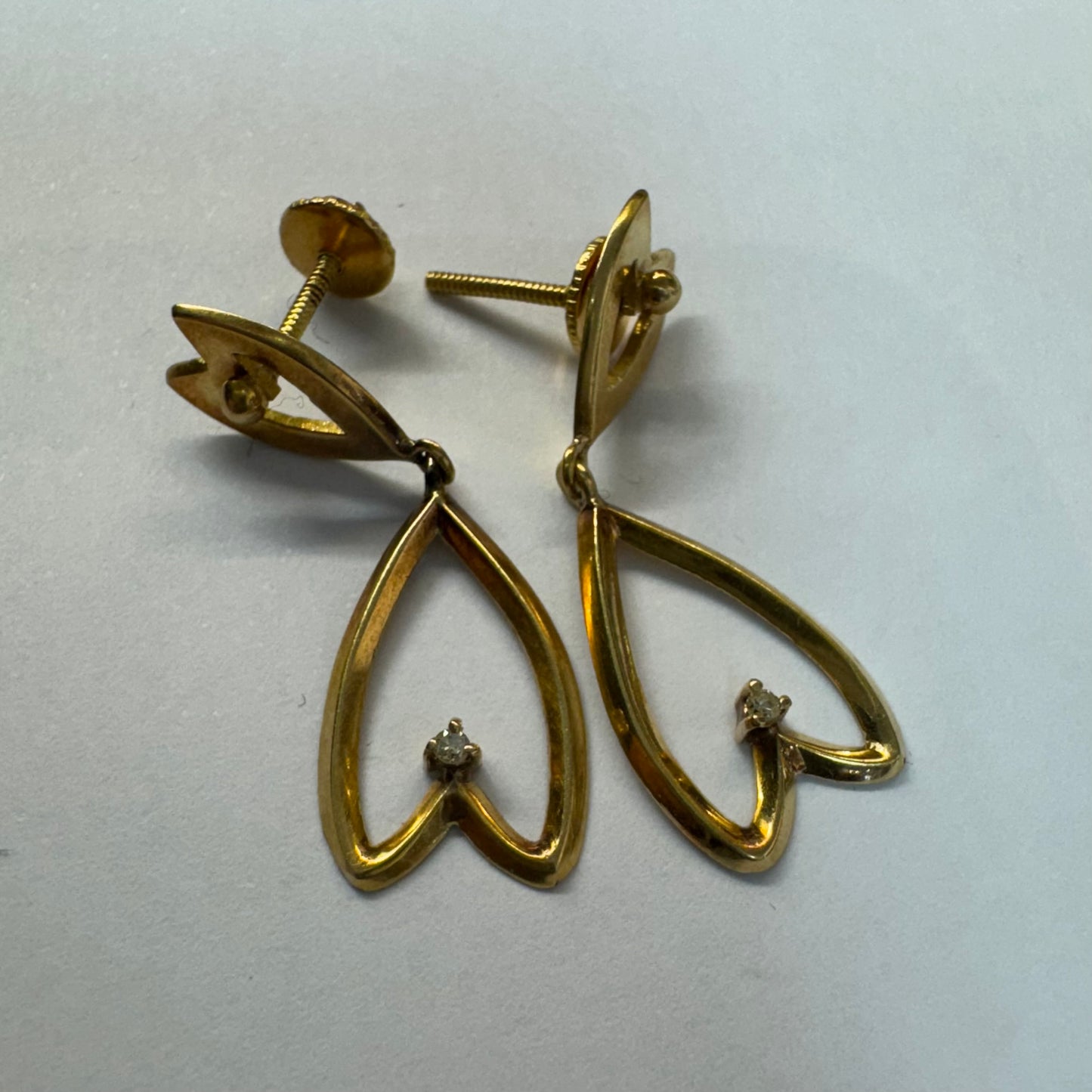 עגילי זהב צהוב 18 קראט בעיצוב עדין ומיוחד בצורת לב, עם יהלום קטן שמוסיף נצנוץ מדויק