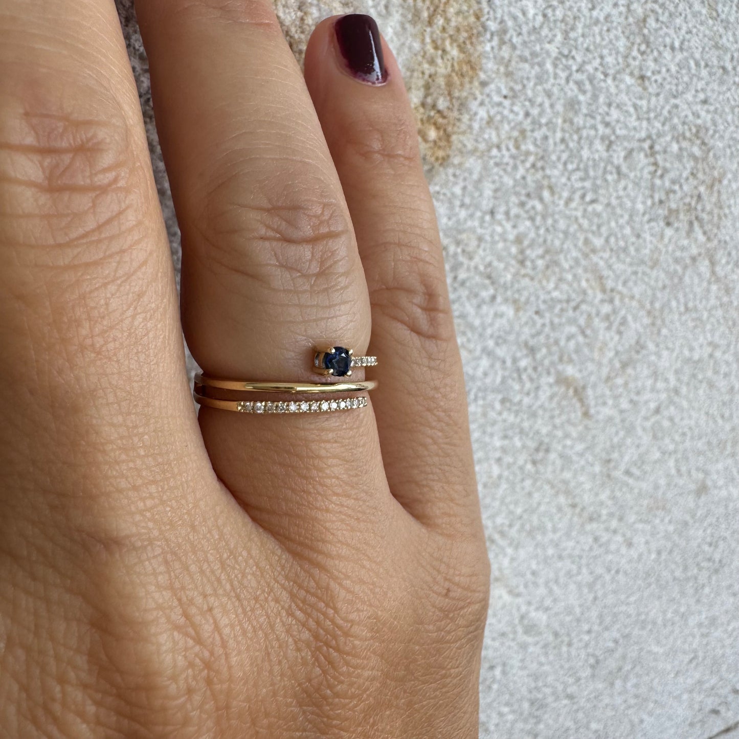 טבעת זהב צהוב 14 קראט משובצת אבן ספיר כחולה ויהלומים נוצצים בשורות עדינות.