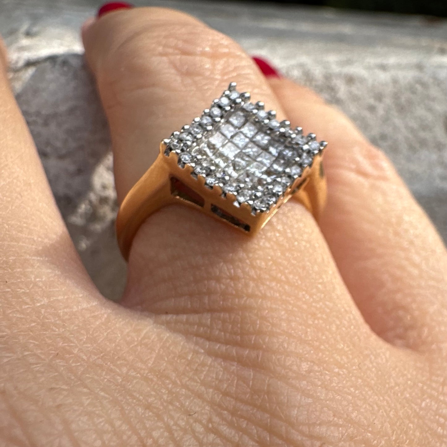 טבעת זהב 14 קראט בעיצוב ריבועי משובצת יהלומים בחיתוך פרינסס ומוקפת מסגרת יהלומים עגולים. 