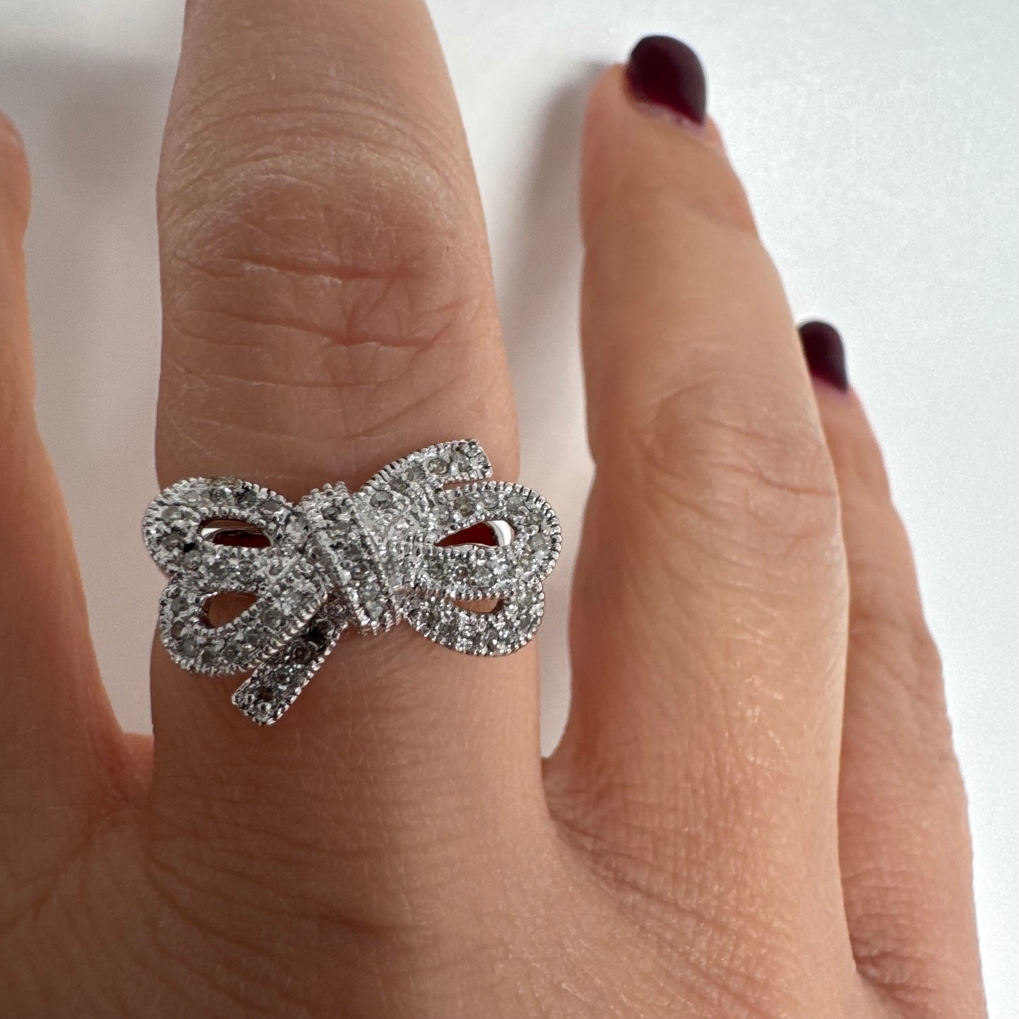 טבעת זהב לבן 14 קראט מעוצבת בצורת פפיון ומשובצת יהלומים בשיבוץ פאבה צפוף.