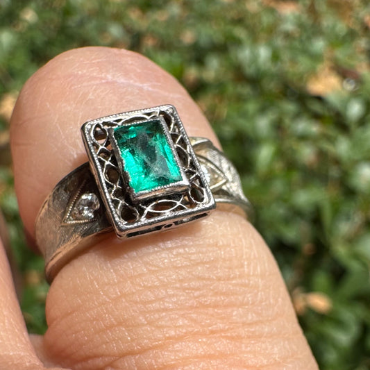 14K gold ring set with a vibrant emerald-cut Emerald at its center, framed by delicate filigree work