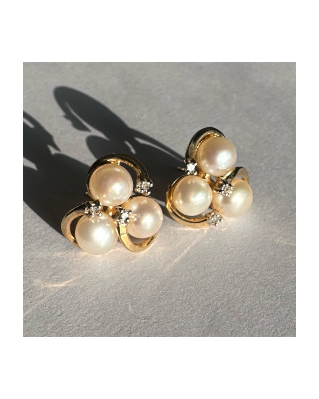 10K gold stud earrings in a delicate floral design, set with three creamy natural Pearls & Diamonds.