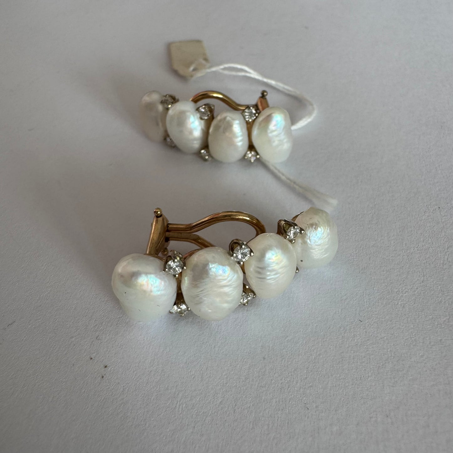 14K gold clip-on earrings set with Pearls accented by sparkling Diamonds between each pearl