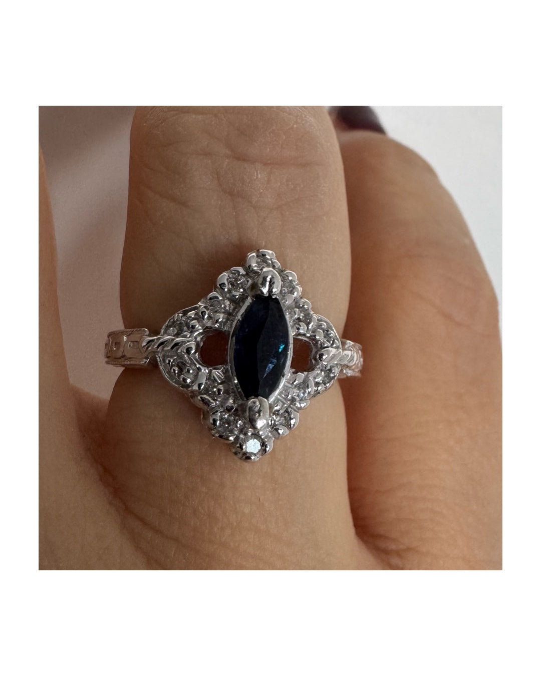טבעת זהב לבן 14 קראט משובצת אבן ספיר בצבע כחול כהה בחיתוך מרקיזה ומסביב משובצים יהלומים