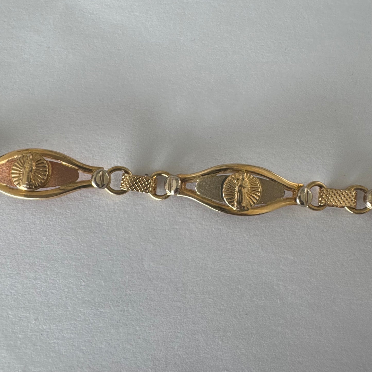 צמיד זהב צהוב 14 קראט עם אלמנט מרכזי בדמות מריה הקדושה, מוקפת קרני אור.