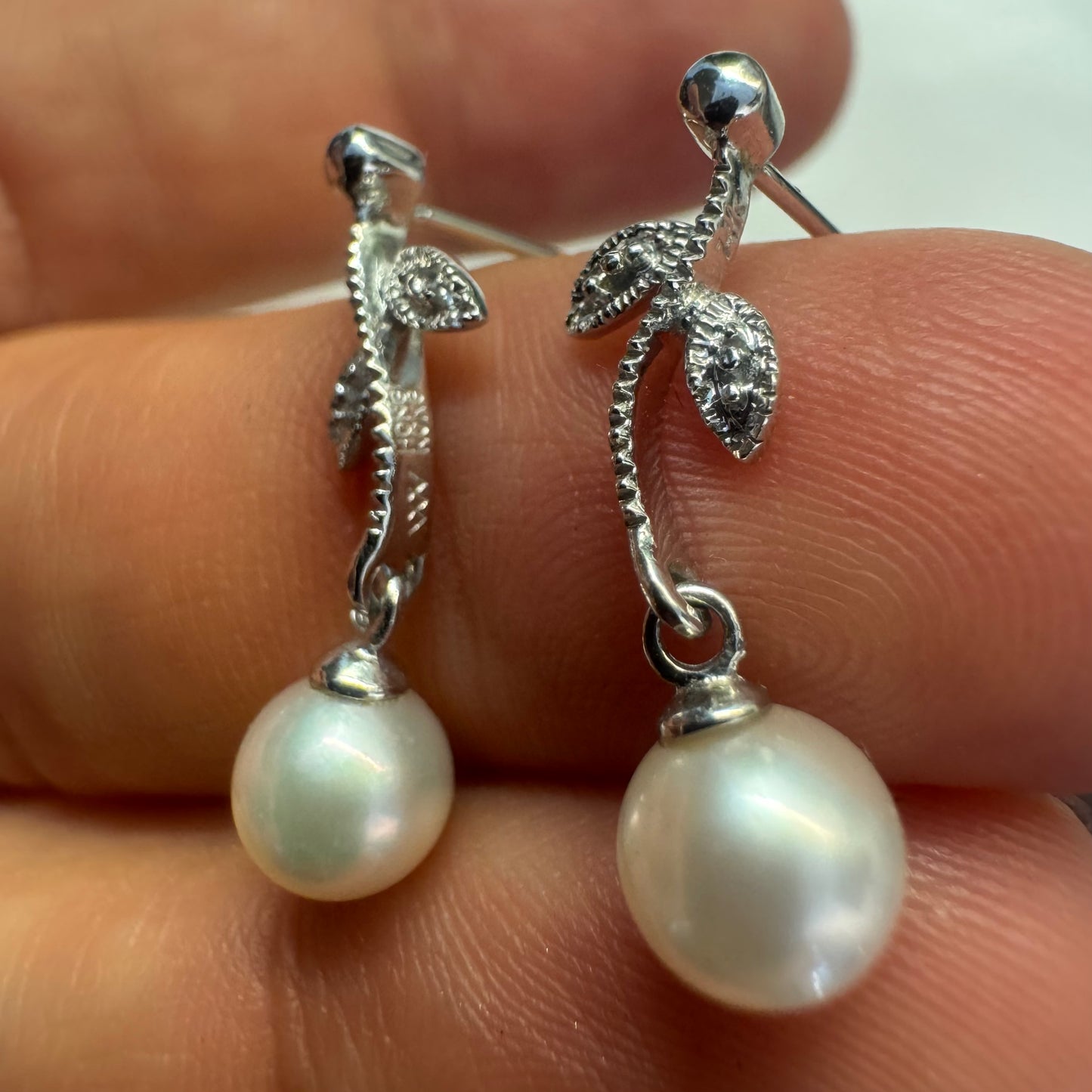 14K gold drop earrings designed with delicate leaf details, each holding a round white Pearl.