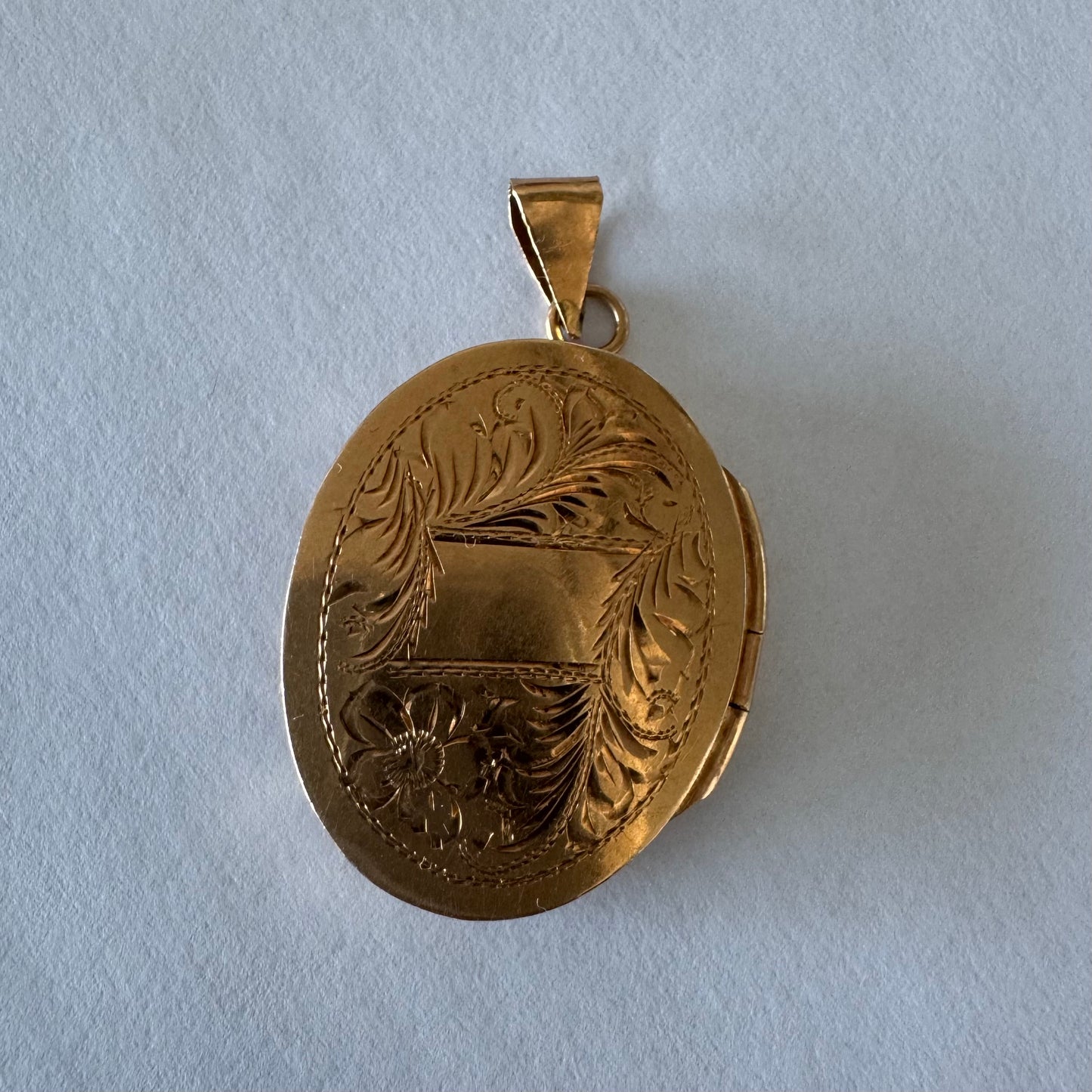 14K gold oval locket pendant delicately hand-engraved with floral motifs