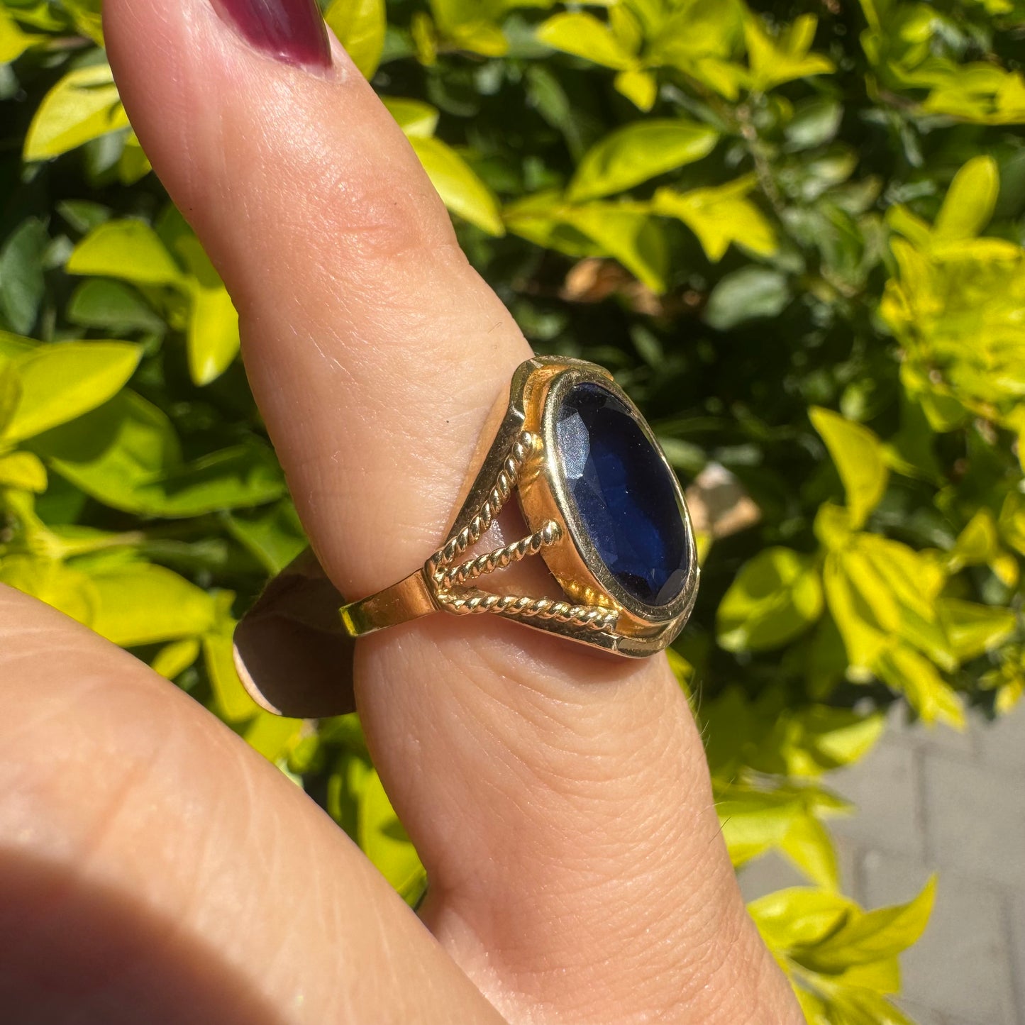 18K yellow gold ring set with a large oval deep blue Sapphire set in an ornate bezel.