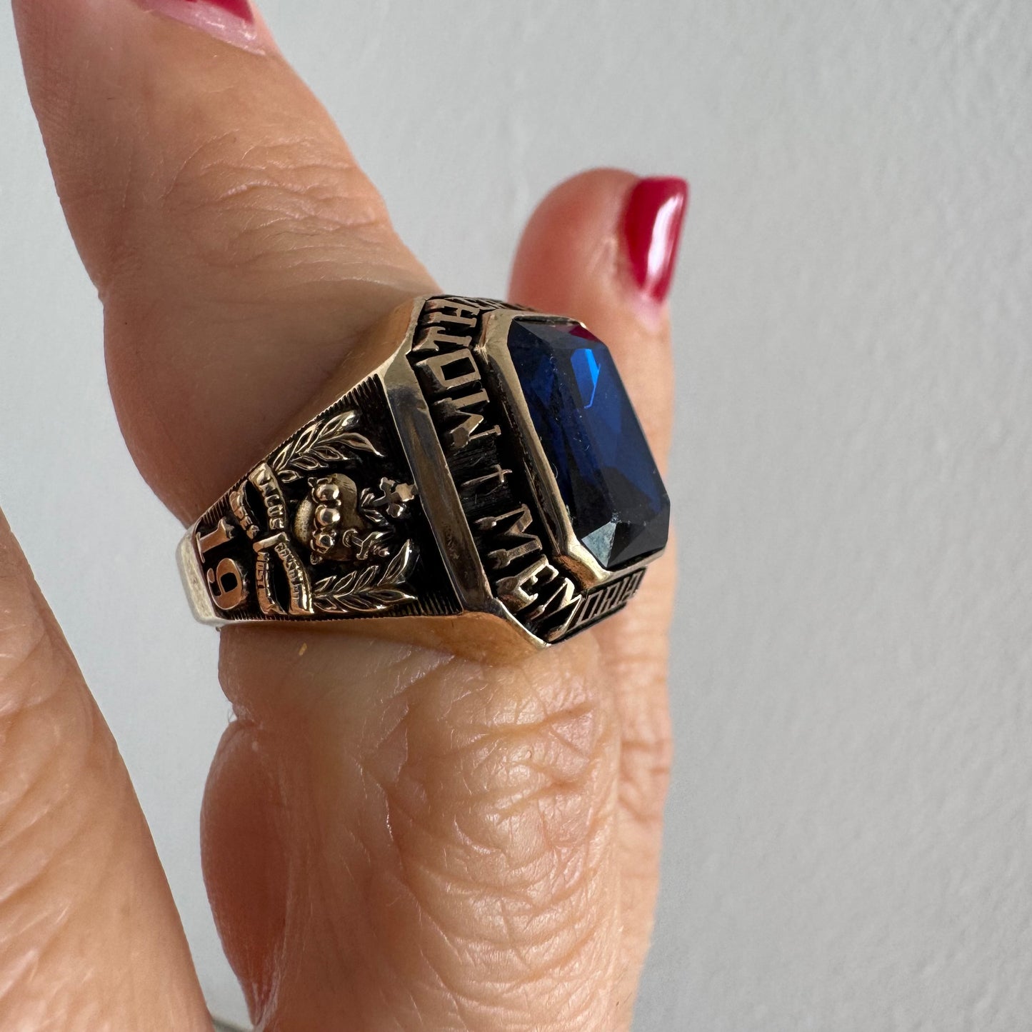 10K gold college ring set with a deep blue faceted stone.