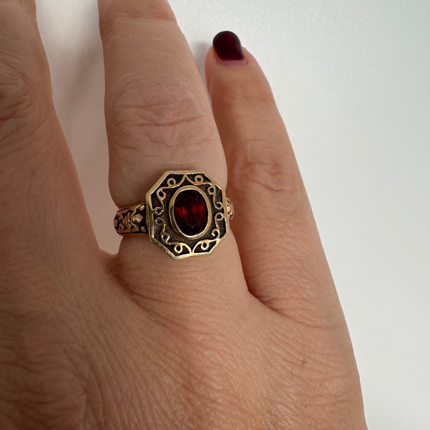 14K gold ring set with an oval deep-red Garnet.