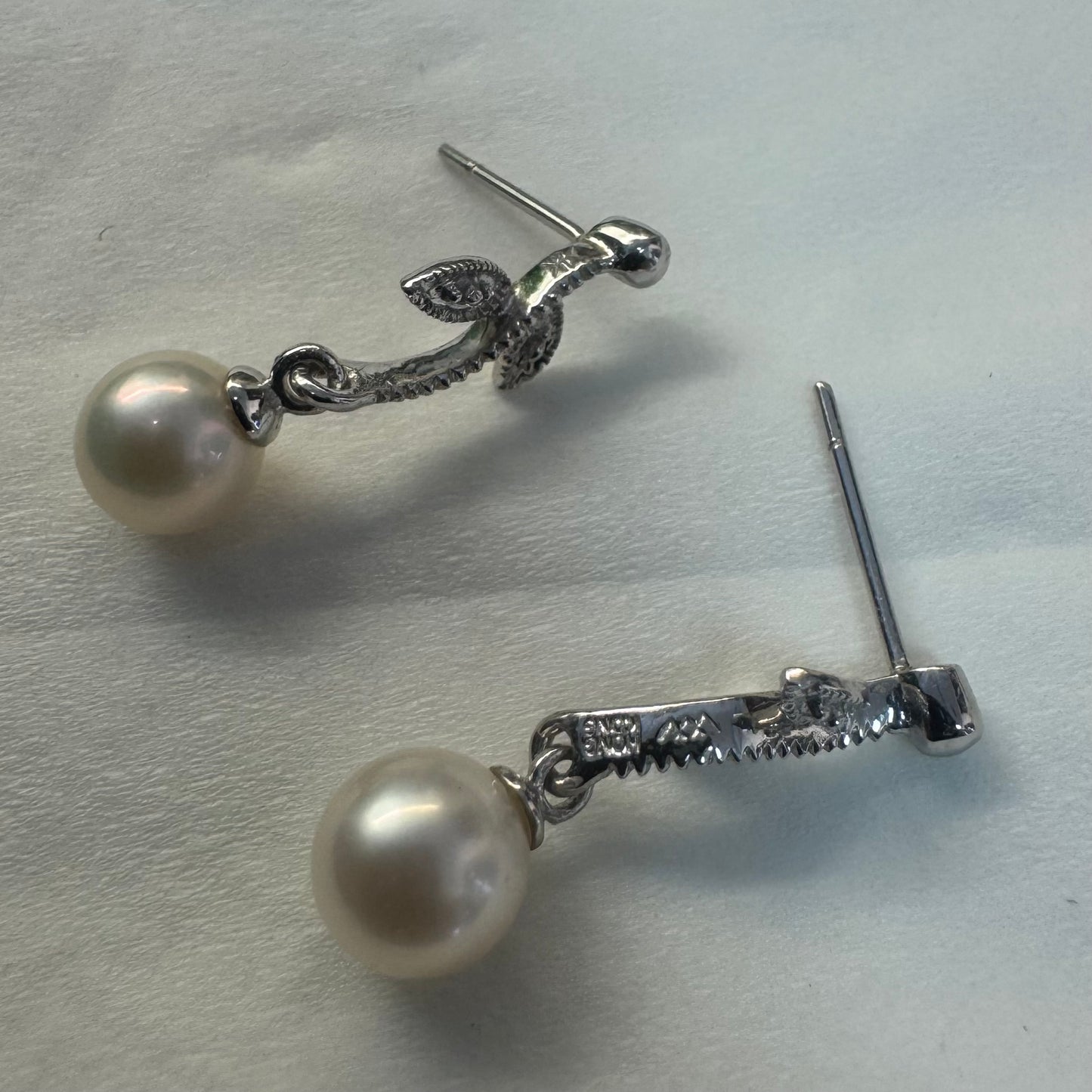 14K gold drop earrings designed with delicate leaf details, each holding a round white Pearl.