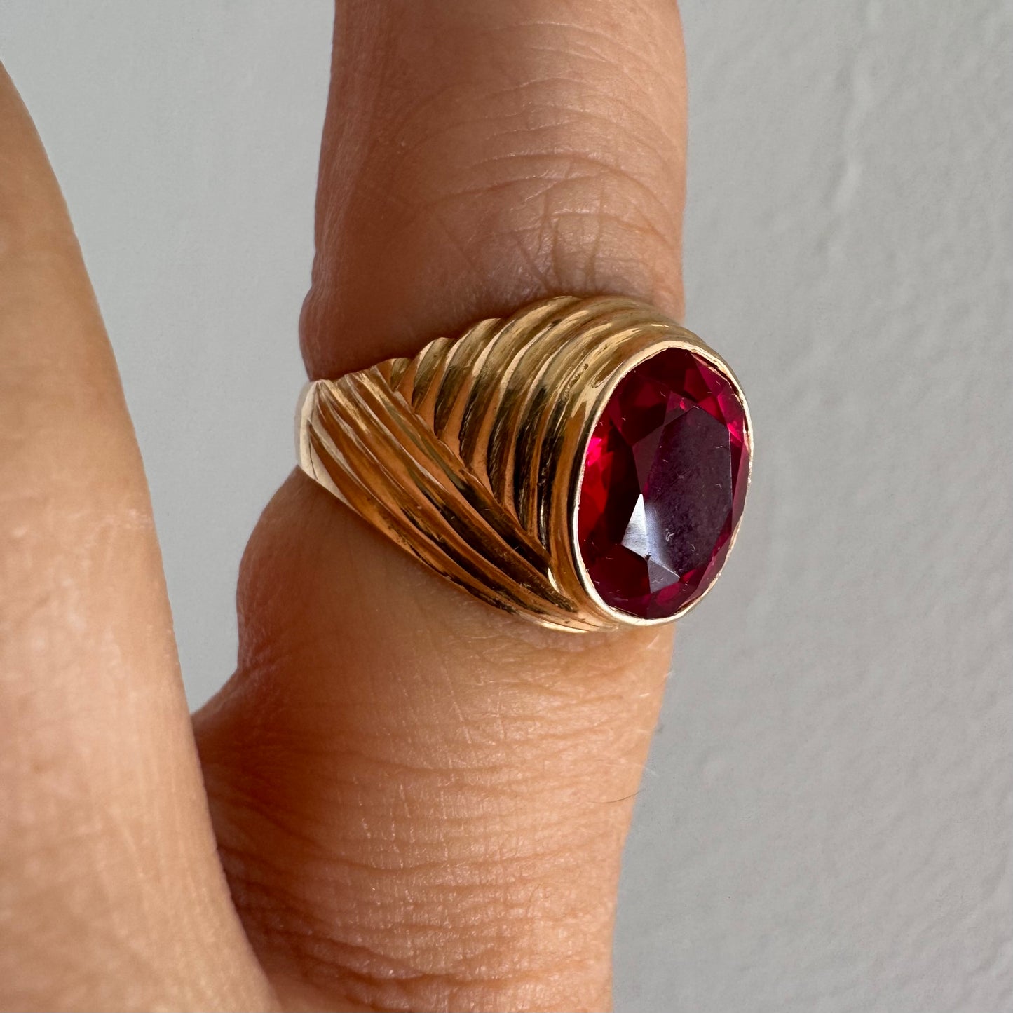 18K gold ring set with a striking oval-cut Ruby gemstone.